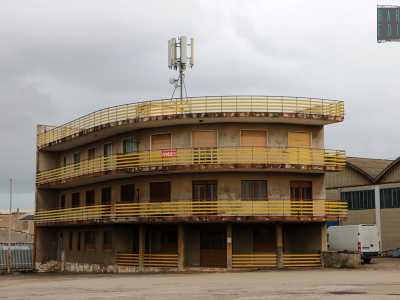 E infine un edificio dal color marrone sbiadito con le ringhiere gialle e recante il manifesto �vendesi�
